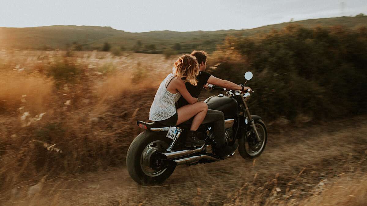 A couple riding a motorcycle