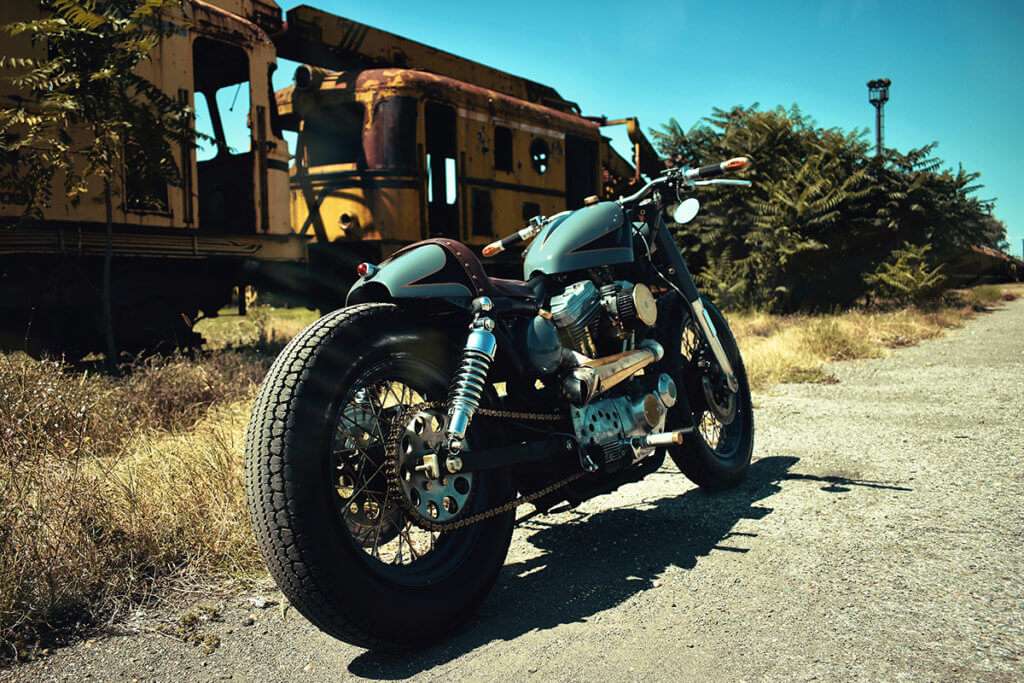 A modified motorcycle next to an old, abandoned train