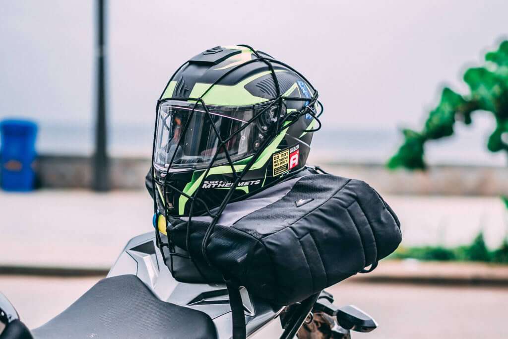 Motorcycle helmet strapped to the back of the motorcycle