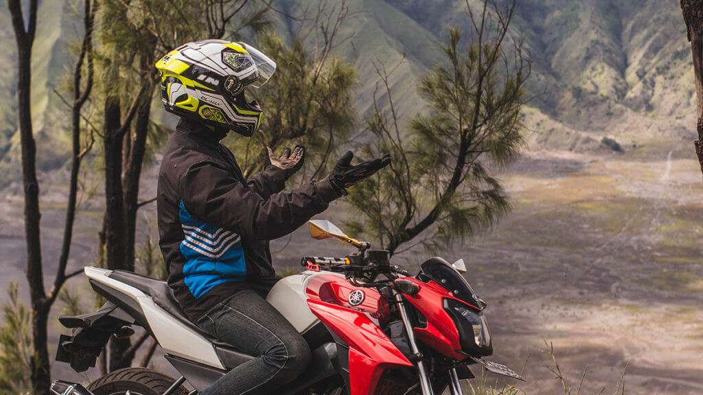 Person with hands out on a motorcycle