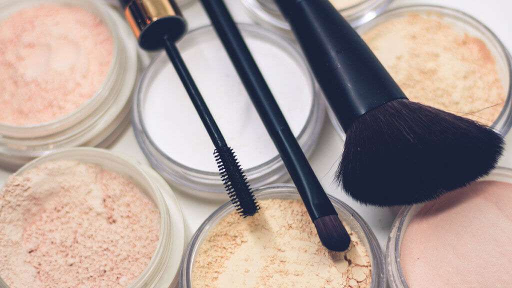 Three makeup brushes on top of powder