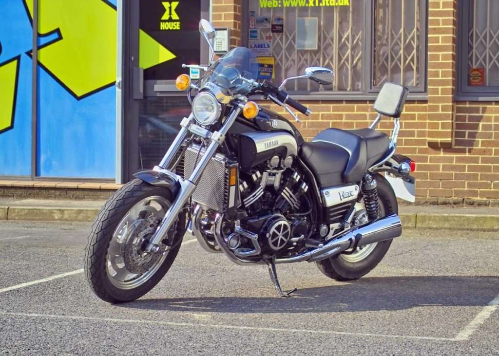 Black and grey motorcycle parked in front of a brick building