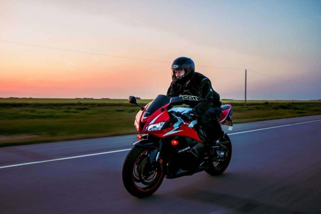 Person riding a red motorcycle wearing a black jacket