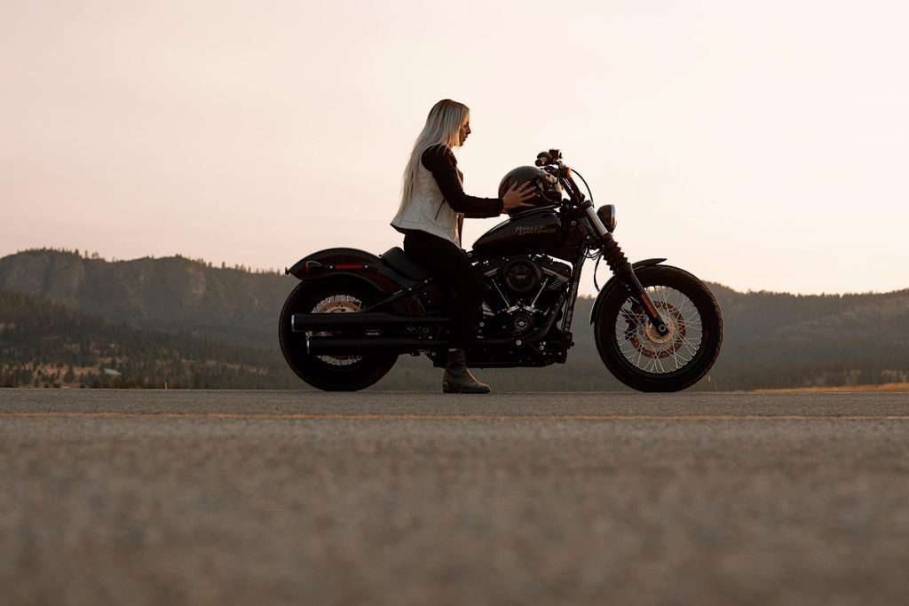 Woman wearing white vest on motorcycle