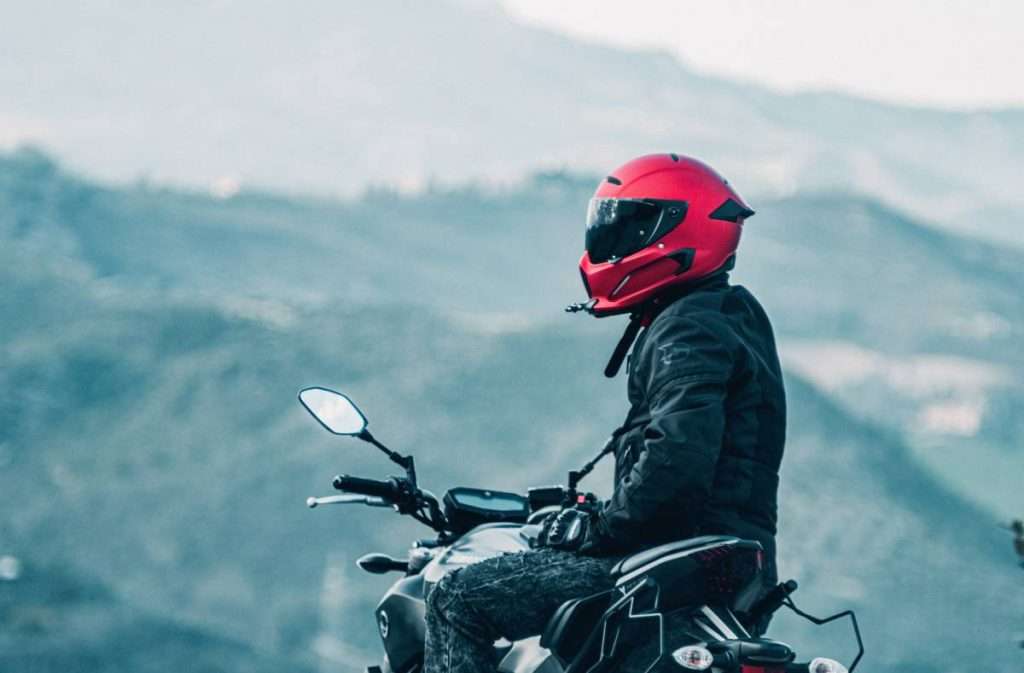 Motorcycle rider wearing a red helmet