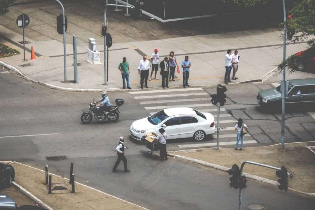 Motorcycle in traffic next to a white car